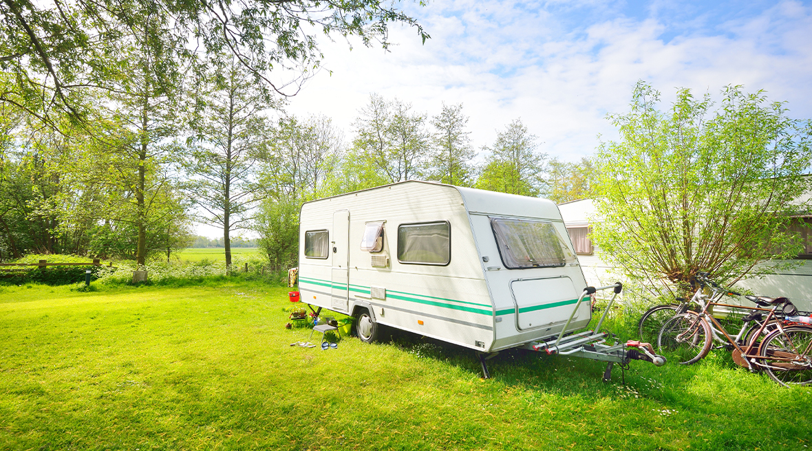 motorhome caravan pitched on green field next to bikes